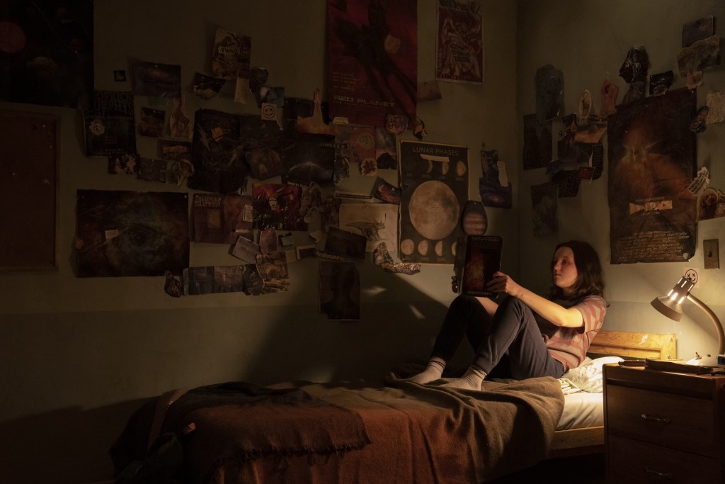 Ellie (Bella Ramsey) lit une bande dessine dans sa chambre